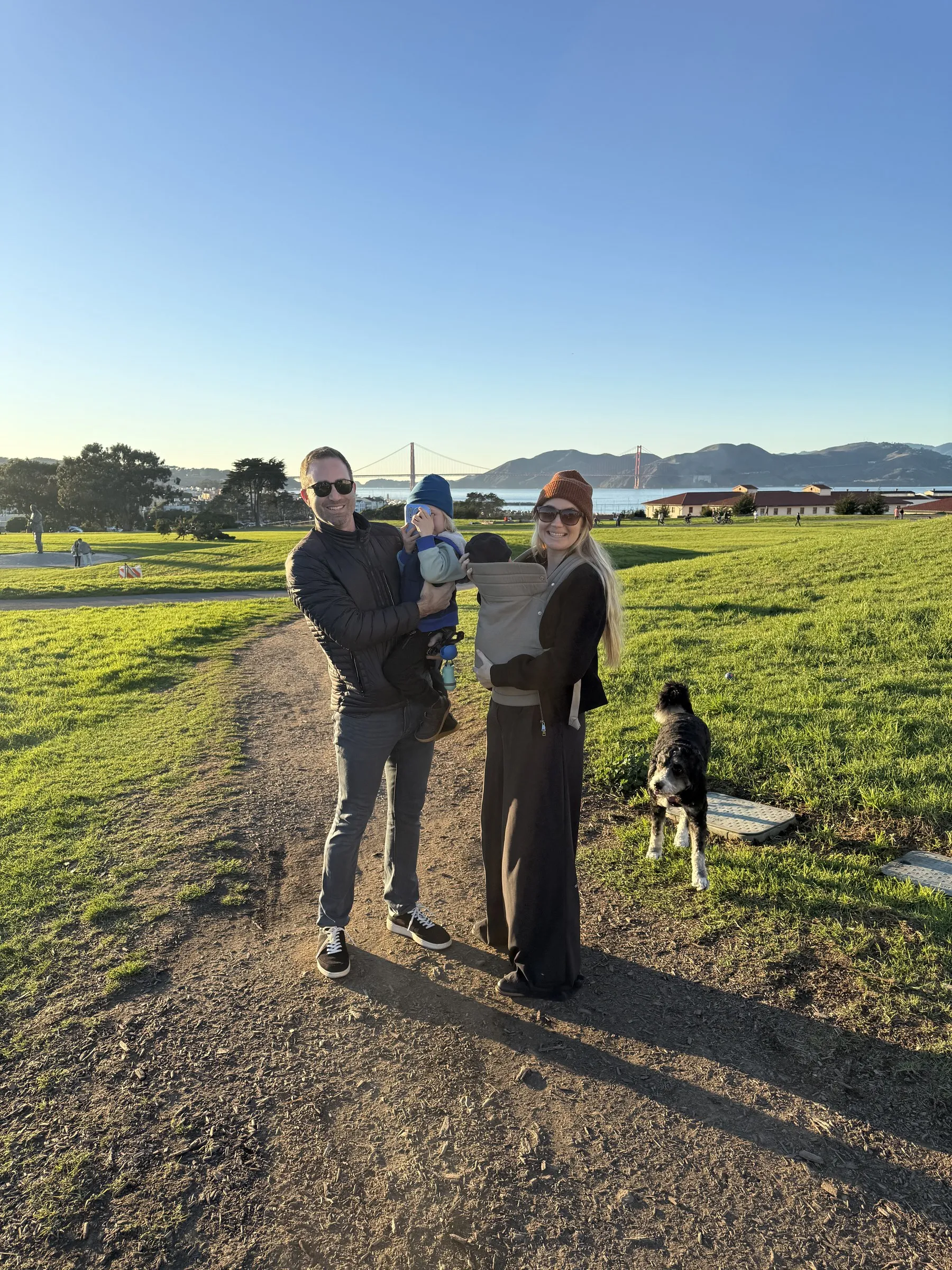 Callie, Patrick, their two boys, and Maple the dog in front of the Golden Gate Bridge
